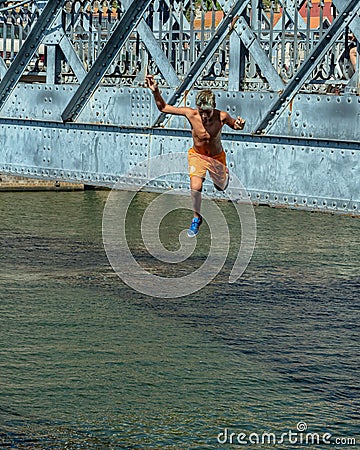 Teenage boy plunging into the River Douro, Porto, Portugal. Editorial Stock Photo