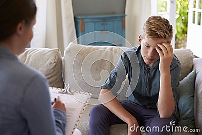 Teenage Boy With Problem Talking With Counselor At Home Stock Photo