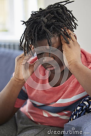 Teenage Boy Sick With Headache At Home Stock Photo