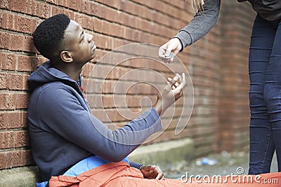 Teenage Boy Sleeping On The Street Being Given Money Stock Photo