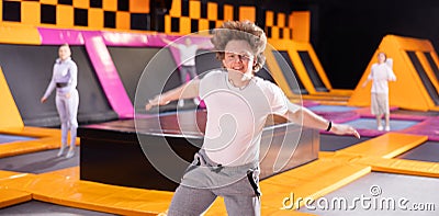 Teenage boy in sport clothes high jumping in trampoline arena Stock Photo