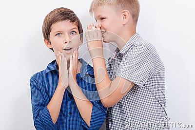 Teenage boy whispering in the ear a secret to Stock Photo