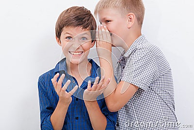 Teenage boy whispering in the ear a secret to Stock Photo