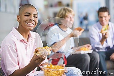 Teenage boys enjoying fast food lunches together Stock Photo
