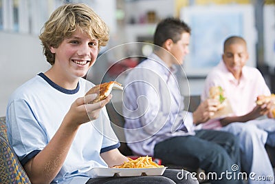 Teenage boys enjoying fast food lunches together Stock Photo