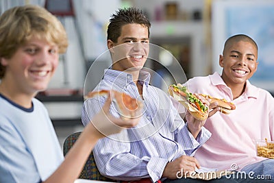 Teenage boys enjoying fast food lunches together Stock Photo