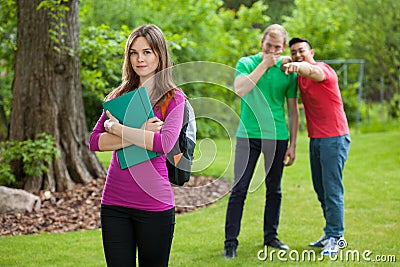 Teenage boys laughing behind girl's back Stock Photo