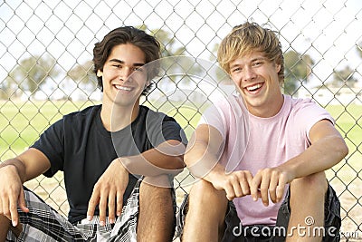 Teenage Boys Sitting In Playground Stock Photo