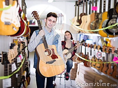 Teenage choosing best acoustic guitar Stock Photo