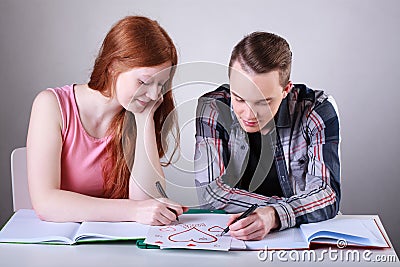 Teenage couple drawing hearts instead of learning Stock Photo