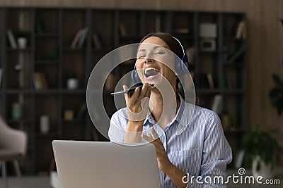 Teenage female sing aloud in headphones record song on phone Stock Photo