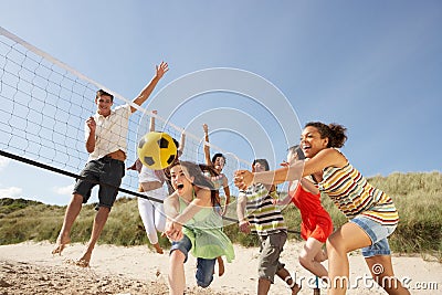 Teenage Friends Playing Volleyball On Beach Stock Photo