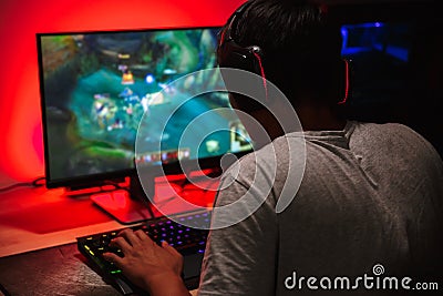 Teenage gamer boy playing video games on computer in dark room, Stock Photo