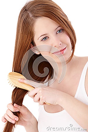 Teenage ginger girl combing long hair Stock Photo