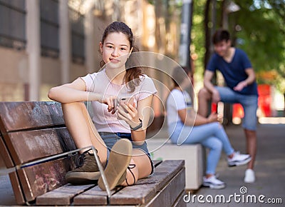 Teenage girl absorbed in social networks on phone Stock Photo