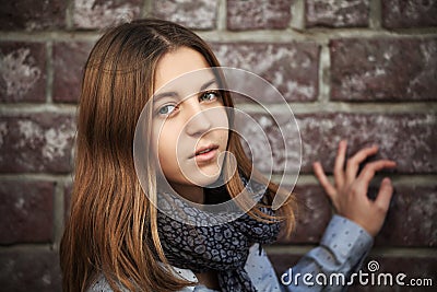 Sad fashion teen girl against a brick wall Stock Photo