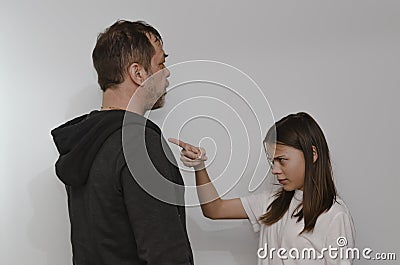 A teenage girl argues with her father on a light background. Stock Photo