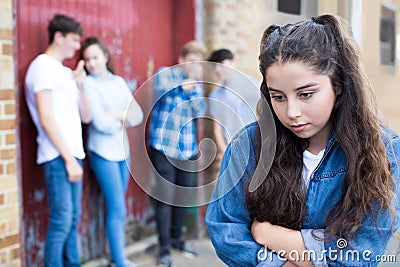 Unhappy Teenage Girl Being Gossiped About By Peers Stock Photo