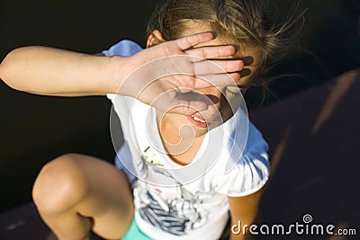 Teenage girl blinks from the sun Stock Photo