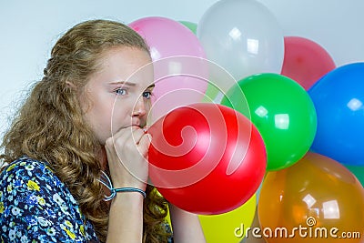 Teenage girl blowing inflating colored balloons Stock Photo