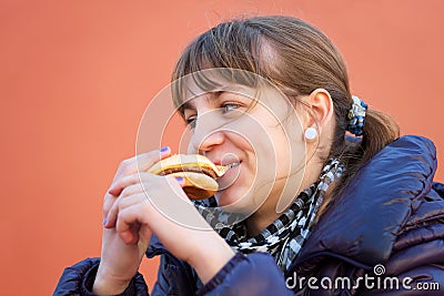 Teenage girl eating a burger Stock Photo