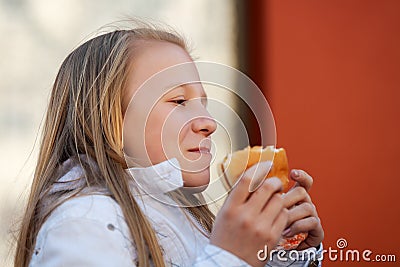 Teenage girl eating a burger Stock Photo