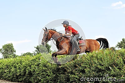 teenage girl equestrian jumping with chestnut horse Stock Photo