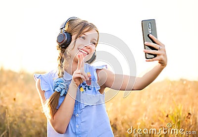 Teenage girl with headphones taking cute selfie Stock Photo
