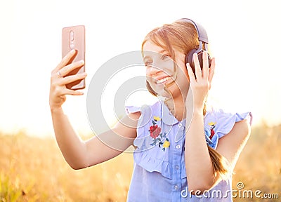 Teenage girl with headphones taking cute selfie Stock Photo