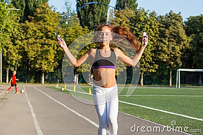 A teenage girl jumping rope in a stadium. Stock Photo