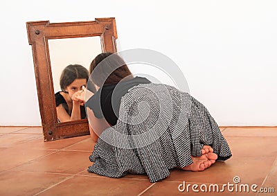 Brunette girl watching herself in mirror Stock Photo