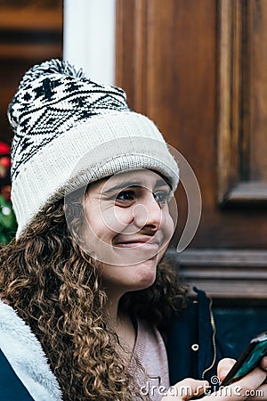 Teenage girl in knit hat with weird facial expression texting wi Stock Photo