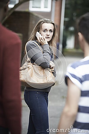 Teenage Girl On Mobile Phone Feeling Intimidated As She Walks Ho Stock Photo