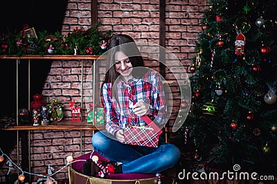 Teenage girl in a plaid shirt opens box Christmas gift Stock Photo