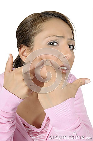 Teenage girl popping zit on face Stock Photo