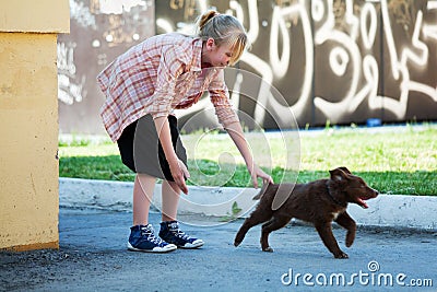 Happy teen girl playing with puppy outdoor Stock Photo