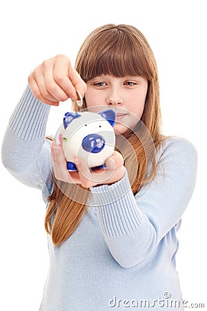 Teenage girl putting coin in piggy bank Stock Photo