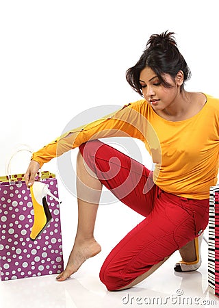 Teenage girl removing her heels after shopping Stock Photo