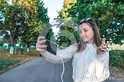 Teenage girl schoolgirl, happy smiling having fun, recording video, video call, teenager headphones taking pictures Stock Photo