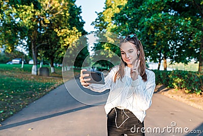 Teenage girl schoolgirl, teenager headphones taking pictures themselves phone, happy smiling having fun, recording video Stock Photo