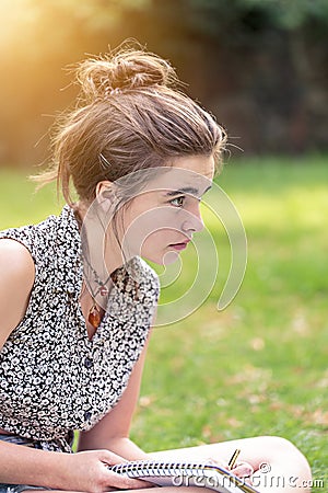 Teenage girl is sitting on a meadow Stock Photo