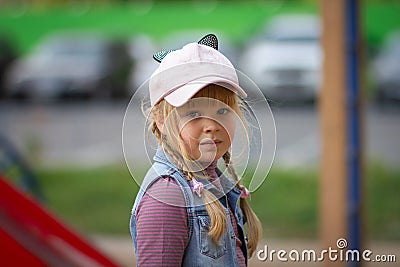 A teenage girl with a slightly disheveled hairstyle looks at the camera. Stock Photo