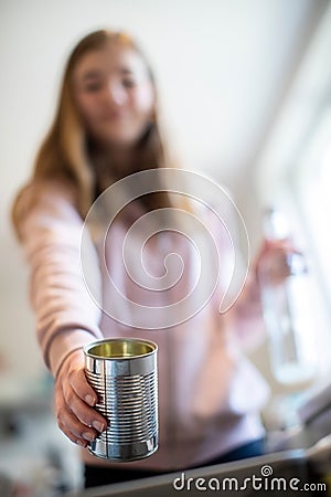 Teenage Girl Sorting Recycling Into Kitchen Bin At Home Stock Photo