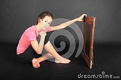 Teenage girl in sportswear sitting in front of mirror Stock Photo