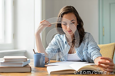 Teenage girl studying reading book at home Stock Photo