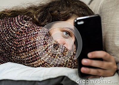 Teenage girl using a smartphone on a bed social media and addiction concept Stock Photo