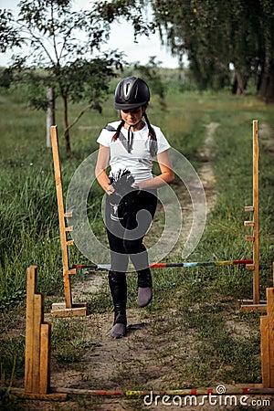 A teenage girl who is fond of hobbyhorsing jumps over obstacles Stock Photo