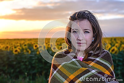 Teenage Girl Wrapped in Blanket in Sunflower Field Stock Photo