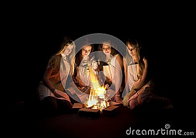 Teenage girls around campfire Stock Photo