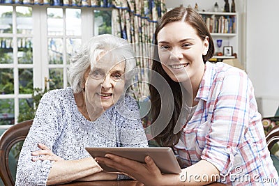 Teenage Granddaughter Showing Grandmother How To Use Digital Tab Stock Photo